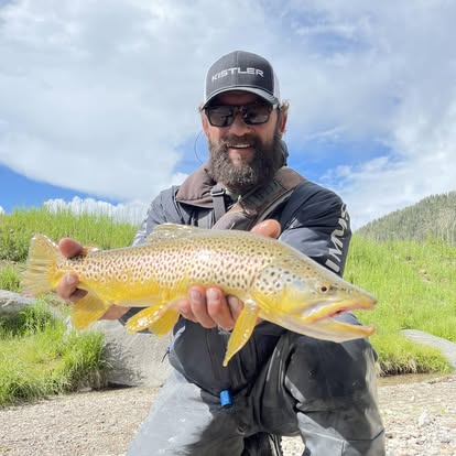 Pat Coburn with a brown trout on the river